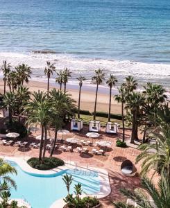 a beach with palm trees and palm trees at Don Carlos Resort & Spa in Marbella