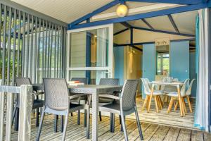 a patio with a table and chairs on a deck at Camping Resort Les Champs Blancs in Agde