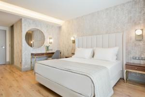 a bedroom with a large white bed and a mirror at Acta The Avenue in Porto