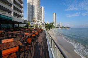 a row of tables and chairs next to the beach at Hompton Hotel by the Beach in George Town