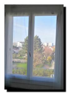 une fenêtre avec vue sur un parc dans l'établissement BnBesak Besancon Micropolis, à Besançon