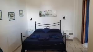 una camera da letto con un letto blu in una stanza di Case Vacanze Marina Longo a Santa Marina Salina Altre 12 foto