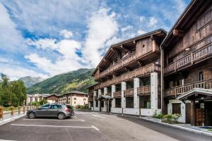 夏蒙尼-勃朗峰Apt. Grand Paradis B14 - Modern with Mont Blanc view的停在建筑物前停车场的汽车
