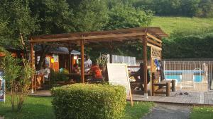 a gazebo with people sitting in it next to a pool at Camping Le Rey in Louvie Juzon