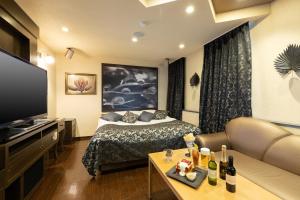 Habitación de hotel con cama y TV en Gifu Mine(Adult Only) en Ginan
