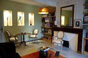 sala de estar con sillas, mesa y espejo en La Baguenaude, en Marciac