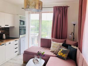 a living room with a pink couch in front of a window at Apartmany Central Liptov in Liptovský Mikuláš +67 photos