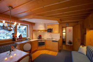 una cocina con armarios de madera y una ventana en una cabaña en Landhaus Marion, en Holzgau
