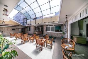 a restaurant with chairs and tables and a glass ceiling at Charlton Kandy City Rest in Kandy