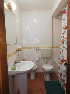 un bagno con un lavandino bianco e un water di Apartamentos Arcada a Quarteira