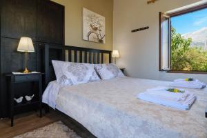 a bedroom with a large bed with a window at Casa Vasilia Traditional Home in Kástellos