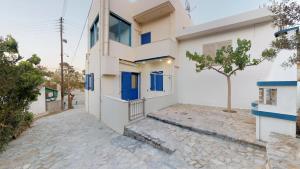 a house with blue doors on a street at Theaktis Homes in Kaloi Limenes