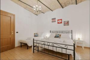 Roma Colosseum Apartment في روما: غرفة نوم بها سريرين وثريا