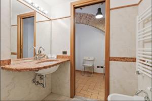Roma Colosseum Apartment في روما: حمام مع حوض ومرحاض ومرآة +15 صورة
