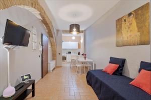 Roma Colosseum Apartment في روما: غرفة نوم مع سرير وغرفة معيشة