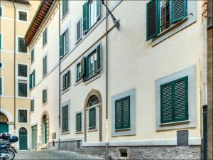 Roma Colosseum Apartment في روما: مبنى نوافذه خضراء ومغلقة على شارع
