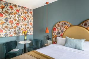 a bedroom with a bed and a floral wall at Hôtel Léopold - Orso Hotels in Paris