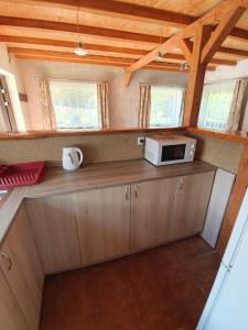 a small kitchen with a microwave on a counter at Domek Adusiówka in Stronie Śląskie