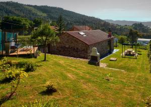 un gran patio con una casa y un cenador en Pedracuca - Costa da Morte, en Neaño