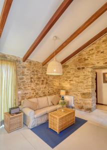 a living room with a couch and a stone wall at Pedracuca - Costa da Morte in Neaño