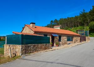 ein Steinhaus am Straßenrand in der Unterkunft Pedracuca - Costa da Morte in Neaño