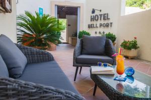 patio z krzesłami i stołem z drinkiem w obiekcie Bell Port Hotel w Cala Ratjada