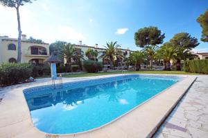 - une piscine en face d'une maison avec des palmiers dans l'établissement Brijon apartment, à Moraira