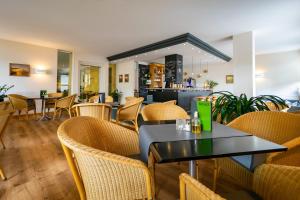 a restaurant with tables and chairs and a counter at Hotel Wald und See in Heringsdorf
