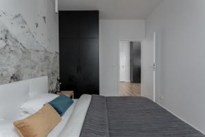 a bedroom with a white bed and white walls at Chill Apartments Central Park in Warsaw