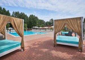 a couple of beds in front of a pool at Villaggio Turistico Lugana Marina in Sirmione