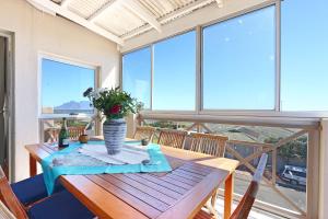 a wooden table with a vase on top of a balcony at Big Bay Penthouse in Big Bay