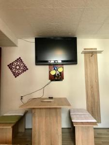 Habitación con mesa y TV en la pared. en Ferienwohnung in Ediger Eller, en Ediger-Eller