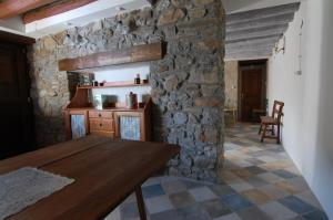 a kitchen with a wooden table and a stone wall at Apartamento El Fenal de Turmo Casa rural "El Capricho de Nieves" in Laspuña