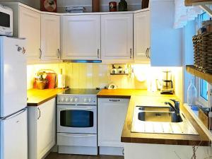 eine Küche mit weißen Schränken und einem Waschbecken in der Unterkunft 6 person holiday home in Ballangen in Ballangen