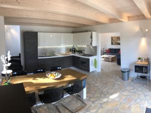a kitchen and living room with a wooden ceiling at Luxurious Holiday Home in Bagni di Lucca with Pool in Bagni di Lucca