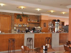 un bar en un restaurante con paredes y taburetes de madera en Hostal Mourelos, en O Grove