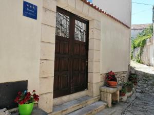 a building with a wooden door and some potted plants at Apartments Ani in Vela Luka