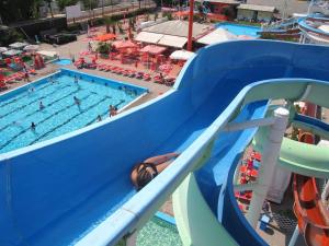 una persona su uno scivolo d'acqua in piscina di Hotel Sirena a Rimini