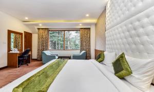 a hotel room with a large bed and a desk at Hotel Snowcrests Manor in Manāli +58 photos