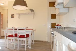 a kitchen with a white table and chairs in a room at La Libellula- casale panoramico con piscina in Versilia in Massarosa