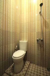 a bathroom with a toilet in a shower stall at RedDoorz at Andalas Asri Lampung in Bandar Lampung