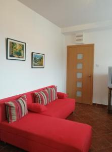 ein rotes Sofa im Wohnzimmer in der Unterkunft Apartments Mitrović Podličak in Sveti Stefan