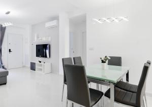 a white dining room with a table and chairs at Apartment Diamante in Pilar de la Horadada