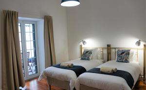 two beds in a room with a window at Heritage Apartments in Funchal