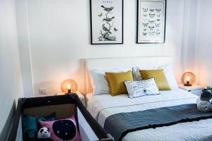 une chambre avec un lit avec des oreillers jaunes et deux lampes dans l'établissement Phaedrus Living Seaview Luxury Flat Lighthouse 53, à Paphos