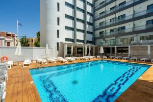 a swimming pool with chairs and a building at Rhodos Horizon City-Adults Only in Rhodes Town