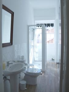 a white bathroom with a toilet and a sink at Heritage Apartments in Funchal