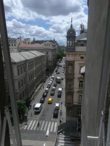 a view of a city street with cars and a clock tower at Next door Apartment in Budapest