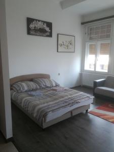 - une chambre avec un lit et une chaise dans l'établissement Next door Apartment, à Budapest