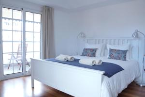um quarto com uma grande cama branca com toalhas em Heritage Apartments no Funchal